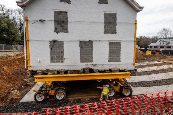 A white hoouse being moved on wheels. 